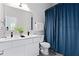 Bright bathroom with double vanity, black hardware, and a stylish blue shower curtain at 514 English Nw Ave, Atlanta, GA 30318