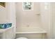 Clean white bathroom features shower and tub with stained-glass window at 650 Somerset Ne Ter, Atlanta, GA 30306