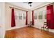 Bright bedroom featuring hardwood floors, two windows, red drapes, and a ceiling fan at 650 Somerset Ne Ter, Atlanta, GA 30306