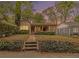 Charming single-story home featuring a brick walkway, red door, and lush landscaping at twilight at 650 Somerset Ne Ter, Atlanta, GA 30306