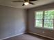 Cozy bedroom with neutral carpet, paint, and plenty of natural light from the large window at 136 Peachtree Memorial Nw Dr # Ga8, Atlanta, GA 30309