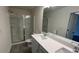 Modern bathroom showcasing double sinks, white countertops, a glass-enclosed shower, and wood-look floors at 36 S Auburn Landing Pl, Auburn, GA 30011