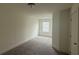 This bedroom is spacious with neutral walls, carpet, and a window to let in natural light at 36 S Auburn Landing Pl, Auburn, GA 30011