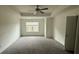 A spacious bedroom featuring neutral carpet, a ceiling fan and a window bringing in natural light at 36 S Auburn Landing Pl, Auburn, GA 30011