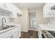 Well-lit kitchen featuring stainless steel appliances, white cabinetry, granite countertops, and wood flooring at 746 Polk Nw St, Marietta, GA 30064