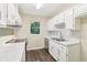 Modern kitchen with white cabinetry, stainless steel appliances, marble countertops, and wood flooring at 746 Polk Nw St, Marietta, GA 30064