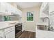 Stylish kitchen featuring stainless steel appliances, granite countertops, white cabinetry, and wood flooring at 746 Polk Nw St, Marietta, GA 30064