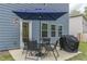 Outdoor patio with table, chairs, grill, and umbrella, adjacent to the home's exterior, perfect for outdoor dining at 9061 Jim Purcell Dr, Covington, GA 30014