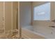 Bathroom featuring a shower and tub, with decorative glass window at 9061 Jim Purcell Dr, Covington, GA 30014