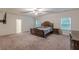 Spacious bedroom featuring a ceiling fan, two windows, and an ornate wooden bed and dresser at 9061 Jim Purcell Dr, Covington, GA 30014