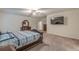 Large open bedroom featuring plush carpet, mounted TV, and open doorway to on-suite bath at 9061 Jim Purcell Dr, Covington, GA 30014