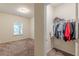 Bedroom that transitions into a walk-in closet with clothes and a single window for natural light at 9061 Jim Purcell Dr, Covington, GA 30014