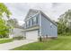 Side view of the home showcasing the blue siding, attached garage, and green lawn, with neighboring houses visible at 9061 Jim Purcell Dr, Covington, GA 30014