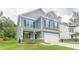 Charming two-story home with a covered porch, a two-car garage, blue siding, and manicured lawn, creating curb appeal at 9061 Jim Purcell Dr, Covington, GA 30014