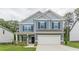 Charming two-story home featuring blue siding, a covered porch, an attached two-car garage, and well-manicured lawn at 9061 Jim Purcell Dr, Covington, GA 30014