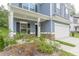 Inviting front porch with white pillars, brick accents, black door, and view of the well-maintained lawn at 9061 Jim Purcell Dr, Covington, GA 30014