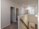 Upstairs hallway with carpeted floors and white walls and trim with multiple doorways at 9061 Jim Purcell Dr, Covington, GA 30014
