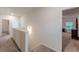 Upstairs hallway with carpeted floors and white walls leads to a bedroom with natural light at 9061 Jim Purcell Dr, Covington, GA 30014