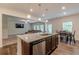 Kitchen island with granite countertops, stainless sink, and wood cabinets near the dining area at 9061 Jim Purcell Dr, Covington, GA 30014