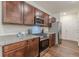 Open kitchen with stainless appliances, granite counters, rich wood cabinets, and wood flooring at 9061 Jim Purcell Dr, Covington, GA 30014