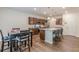 Eat-in kitchen features an island with bar seating, stainless appliances, granite counters, and rich wood cabinets at 9061 Jim Purcell Dr, Covington, GA 30014