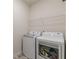 Laundry room featuring new, white, front-loading washer and dryer with wire shelf above at 9061 Jim Purcell Dr, Covington, GA 30014