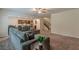 Open-concept living room featuring a sectional sofa and seamlessly connected to the kitchen and staircase at 9061 Jim Purcell Dr, Covington, GA 30014