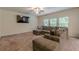 Spacious living room with a large sectional sofa, ceiling fan, and plenty of natural light at 9061 Jim Purcell Dr, Covington, GA 30014