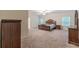 Spacious main bedroom with carpet floors, ceiling fan, and dark wood furnishings at 9061 Jim Purcell Dr, Covington, GA 30014