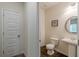 A clean and modern powder room with pedestal sink and decorative mirror at 9061 Jim Purcell Dr, Covington, GA 30014