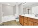 Full bathroom features a double sink vanity, and separate tub and shower at 1080 Treymont Ln, Lawrenceville, GA 30045
