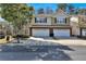 Two-story townhome with a two-car garage, brick accents, and a well-maintained front yard under a blue sky at 1080 Treymont Ln, Lawrenceville, GA 30045