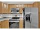 Close-up of kitchen appliances including a stainless steel refrigerator, electric range, and microwave at 1080 Treymont Ln, Lawrenceville, GA 30045