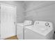 Laundry room with white washer and dryer, white wire shelves, and a white door at 1080 Treymont Ln, Lawrenceville, GA 30045