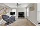 Spacious living room with stairs, two large windows, a ceiling fan, and a comfortable massage chair at 1080 Treymont Ln, Lawrenceville, GA 30045