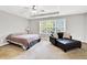Spacious main bedroom featuring a ceiling fan, large windows and an ensuite seating area at 1080 Treymont Ln, Lawrenceville, GA 30045