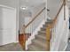 Carpeted staircase with white railings, wood trim, and a view of the front entryway at 1080 Treymont Ln, Lawrenceville, GA 30045
