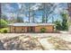Ranch style house showing the front brick and wood exterior, lawn, and mature trees at 5415 Orly Ter, Atlanta, GA 30349