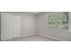 This bedroom features neutral carpeting, closet and a double window at 2544 Peyton Woods Sw Trl, Atlanta, GA 30311