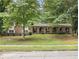 Traditional brick home with arched porch features and a lush, tree-filled front yard at 2544 Peyton Woods Sw Trl, Atlanta, GA 30311