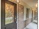 Elegant front door with decorative glass, brick facade, and covered entrance featuring exterior lighting at 2544 Peyton Woods Sw Trl, Atlanta, GA 30311