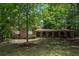 Charming brick home featuring an arched front porch and a lush, green, tree-filled front yard at 2544 Peyton Woods Sw Trl, Atlanta, GA 30311