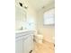 Clean bathroom featuring a white vanity, a toilet, a mirror, and a window providing natural light at 2563 Hamill Dr, Buford, GA 30519