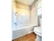 Bathroom featuring a white tiled shower and bathtub, and a toilet next to a window at 2563 Hamill Dr, Buford, GA 30519