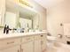 Bathroom with a dual vanity, a mirror, and a toilet next to a window with a curtain at 2563 Hamill Dr, Buford, GA 30519