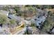 Overhead view of the community featuring mature landscaping, winding roads, and charming townhomes with dark gray roofs at 1 Mooregate Sq, Atlanta, GA 30327