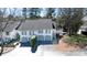 An aerial view of a lovely townhome showcasing its neatly paved driveway, manicured lawn, and surrounding mature trees at 1 Mooregate Sq, Atlanta, GA 30327