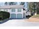 Inviting two-story townhome with teal accents, a well-maintained lawn, and a paved driveway at 1 Mooregate Sq, Atlanta, GA 30327