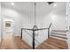 Bright landing features hardwood floors, modern railings, and a chandelier at 1 Mooregate Sq, Atlanta, GA 30327