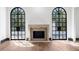 Charming living room with a stone fireplace flanked by large arched windows, enhancing the room's character at 1 Mooregate Sq, Atlanta, GA 30327